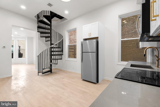 1805 Chestnut St, Philadelphia, PA 19103 - kitchen featuring stainless steel appliances, white cabinets, light wood finished floors, light stone countertops, and recessed lighting