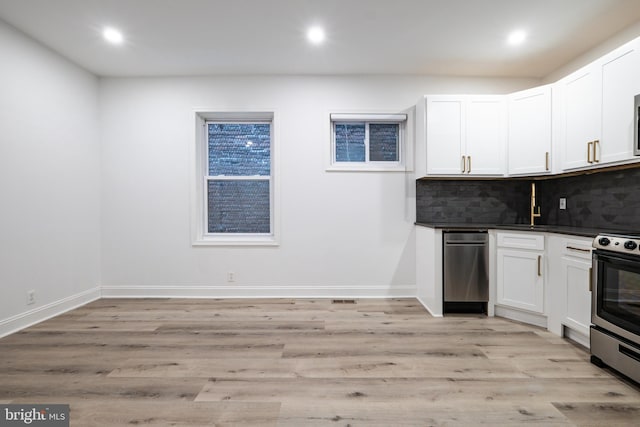 1805 Chestnut St, Philadelphia, PA 19103 - kitchen with stainless steel electric stove, backsplash, dark countertops, light wood-style floors, and recessed lighting