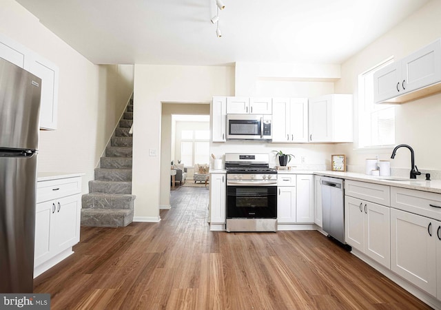 535 N Decker Ave, Baltimore, MD 21205 - kitchen with appliances with stainless steel finishes, light countertops, wood finished floors, and white cabinets