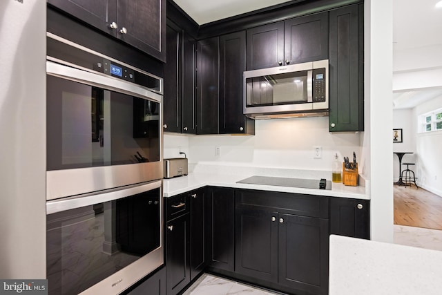 1227 Cross Rd, Annapolis, MD 21403 - kitchen with appliances with stainless steel finishes, light countertops, light marble finish floors, and dark cabinetry