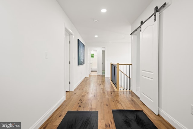 1227 Cross Rd, Annapolis, MD 21403 - hall featuring a barn door, light wood-style floors, recessed lighting, and an upstairs landing