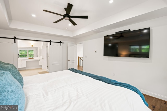 1227 Cross Rd, Annapolis, MD 21403 - bedroom featuring a raised ceiling, wood finished floors, a barn door, recessed lighting, and ceiling fan
