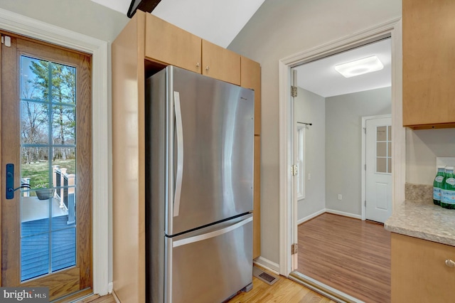 10828 Moore Dr, Manassas, VA 20111 - kitchen featuring freestanding refrigerator, light wood-type flooring, light stone counters, and light brown cabinetry