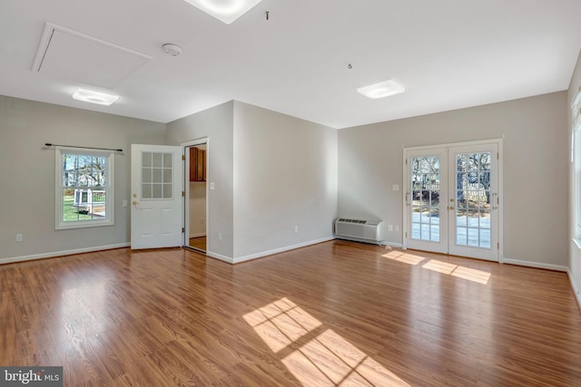 10828 Moore Dr, Manassas, VA 20111 - unfurnished room featuring french doors, an AC wall unit, wood finished floors, and attic access