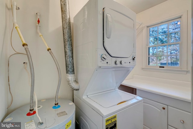 10828 Moore Dr, Manassas, VA 20111 - laundry room featuring stacked washing machine and dryer, cabinet space, and water heater
