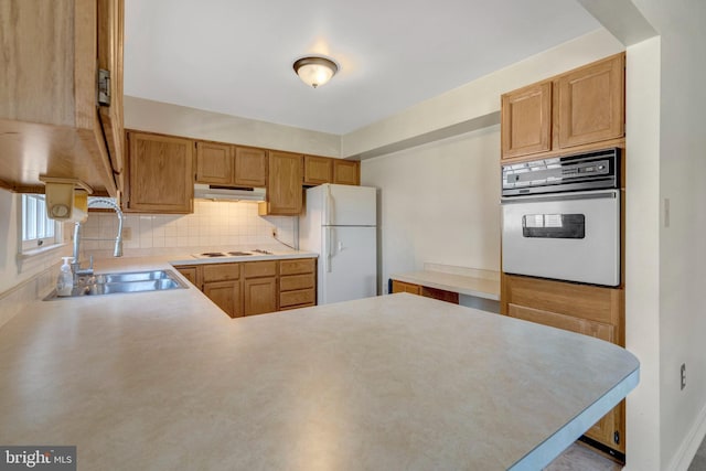 10828 Moore Dr, Manassas, VA 20111 - kitchen with white appliances, under cabinet range hood, decorative backsplash, and light countertops