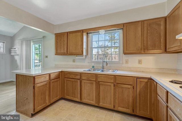 10828 Moore Dr, Manassas, VA 20111 - kitchen featuring a peninsula, light countertops, brown cabinetry, and vaulted ceiling