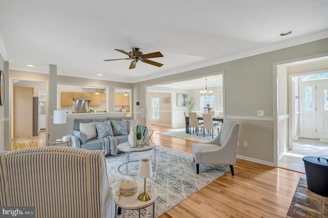 10828 Moore Dr, Manassas, VA 20111 - living area with light wood finished floors, crown molding, a ceiling fan, and a chandelier