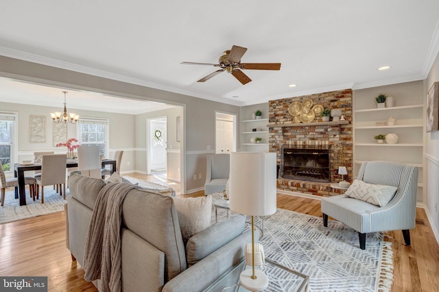 10828 Moore Dr, Manassas, VA 20111 - living area with a chandelier, light wood-style floors, a brick fireplace, built in features, and a ceiling fan