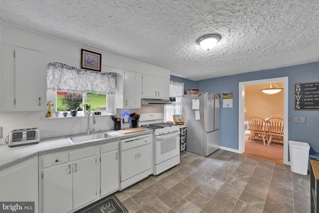 755 W Market St, Orwigsburg, PA 17961 - kitchen with white appliances, light countertops, tasteful backsplash, white cabinets, and under cabinet range hood