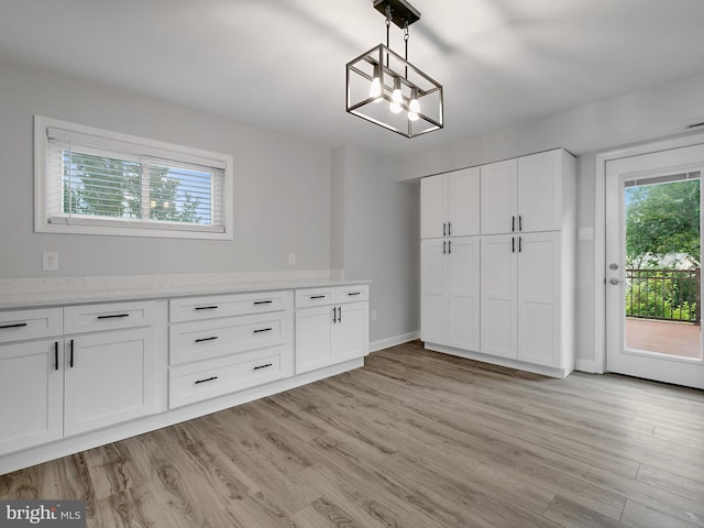 7811 Harbor Rd, Pasadena, MD 21122 - unfurnished dining area with plenty of natural light, light wood-style flooring, and a chandelier