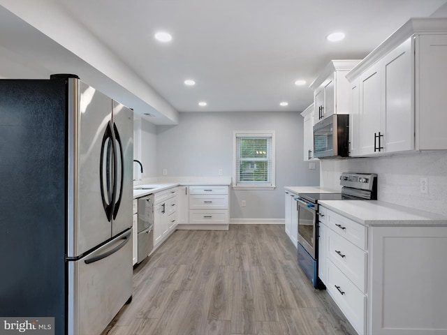 7811 Harbor Rd, Pasadena, MD 21122 - kitchen featuring stainless steel appliances, light countertops, white cabinets, light wood-style flooring, and recessed lighting