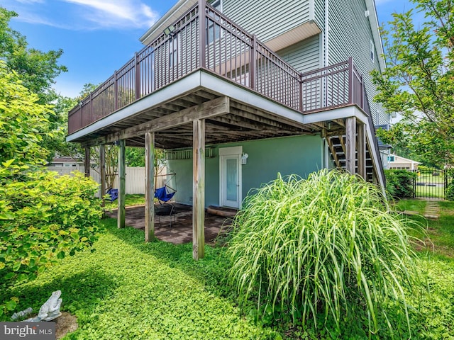 7811 Harbor Rd, Pasadena, MD 21122 - back of property with a wooden deck, stairway, and a patio area