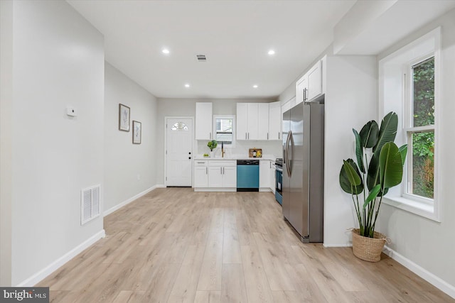 3209 Grayson St, Baltimore, MD 21216 - kitchen with stainless steel appliances, white cabinetry, light wood-style flooring, light countertops, and recessed lighting