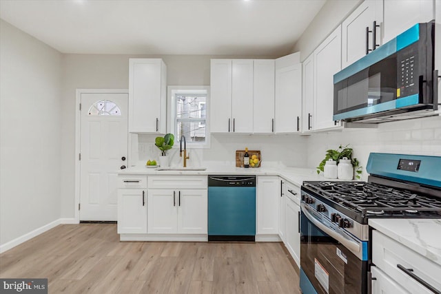 3209 Grayson St, Baltimore, MD 21216 - kitchen with appliances with stainless steel finishes, white cabinetry, and light wood-style flooring