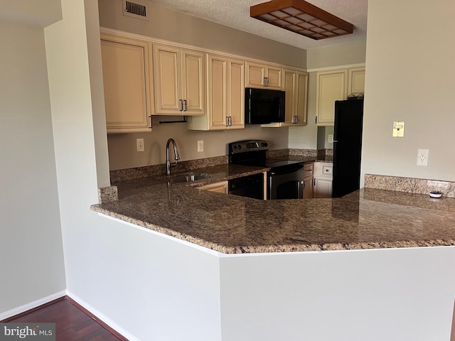 2100 Langston Blvd Unit 406, Arlington, VA 22201 - kitchen with black appliances, cream cabinets, dark stone countertops, a peninsula, and wood finished floors