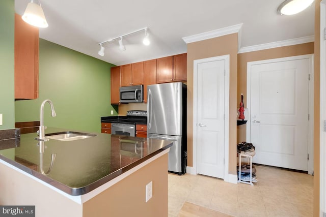 1391 Pennsylvania Ave SE Unit 247, Washington, DC 20003 - kitchen with stainless steel appliances, a peninsula, rail lighting, brown cabinetry, and light tile patterned floors