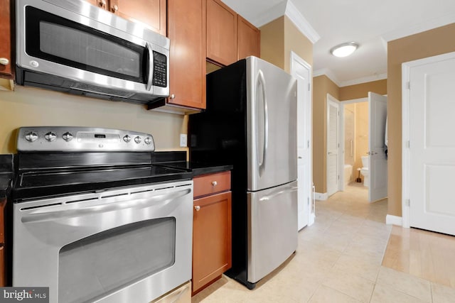 1391 Pennsylvania Ave SE Unit 247, Washington, DC 20003 - kitchen featuring stainless steel appliances, ornamental molding, dark countertops, light tile patterned floors, and brown cabinetry