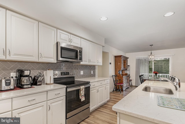 2069 Spring Wood Ln, Mechanicsburg, PA 17055 - kitchen featuring appliances with stainless steel finishes, white cabinetry, tasteful backsplash, light wood finished floors, and recessed lighting