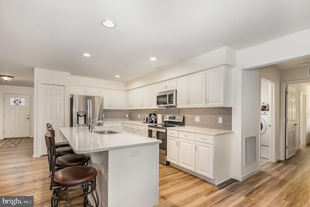 2069 Spring Wood Ln, Mechanicsburg, PA 17055 - kitchen featuring appliances with stainless steel finishes, a kitchen bar, white cabinets, backsplash, and recessed lighting