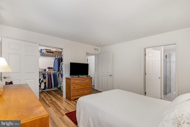 2069 Spring Wood Ln, Mechanicsburg, PA 17055 - bedroom featuring light wood finished floors, a spacious closet, a closet, and ensuite bathroom