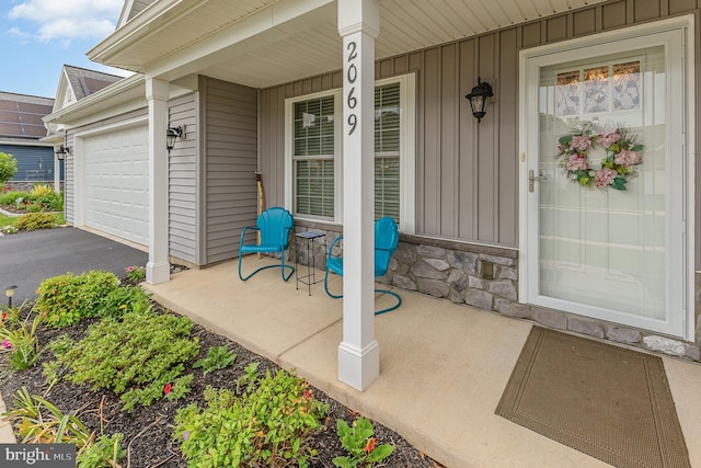 2069 Spring Wood Ln, Mechanicsburg, PA 17055 - entrance to property featuring board and batten siding, stone siding, a porch, a garage, and asphalt driveway