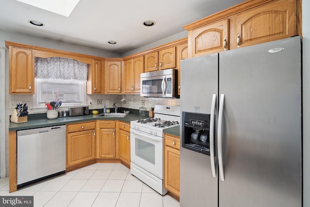 122 Randolph Ave, South Plainfield, NJ 07080 - kitchen with stainless steel appliances, a skylight, dark countertops, backsplash, and light tile patterned flooring