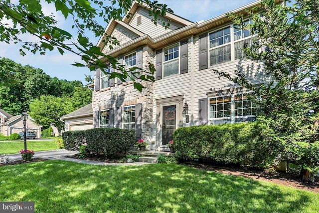 64 S 3rd St, New Freedom, PA 17349 - view of front facade featuring stone siding, a front yard, and an attached garage