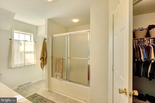 64 S 3rd St, New Freedom, PA 17349 - full bath featuring bath / shower combo with glass door, tile patterned flooring, and a walk in closet