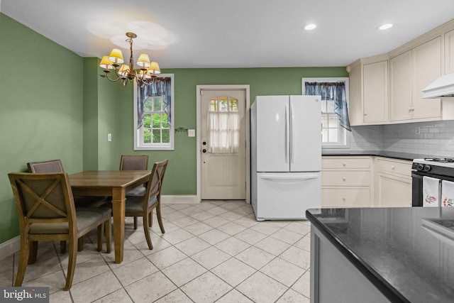 613 Arbor Rd, Cheltenham, PA 19012 - kitchen with freestanding refrigerator, stove, dark countertops, a chandelier, and tasteful backsplash