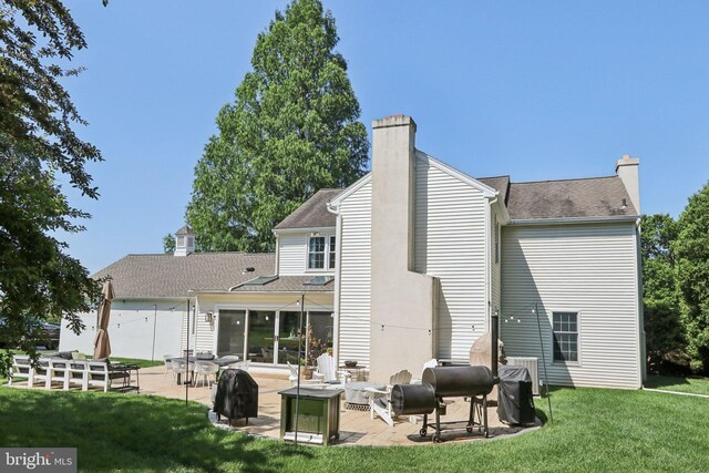 1118 Dorset Dr, West Chester, PA 19382 - back of property featuring a chimney, a patio area, a lawn, and roof with shingles