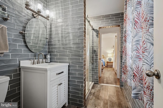644 Chester River Beach Rd, Grasonville, MD 21638 - bathroom featuring wood finished floors, a stall shower, tile walls, and vanity