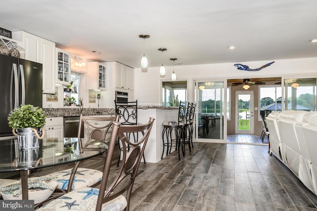 644 Chester River Beach Rd, Grasonville, MD 21638 - kitchen featuring appliances with stainless steel finishes, glass insert cabinets, a kitchen breakfast bar, a ceiling fan, and white cabinetry