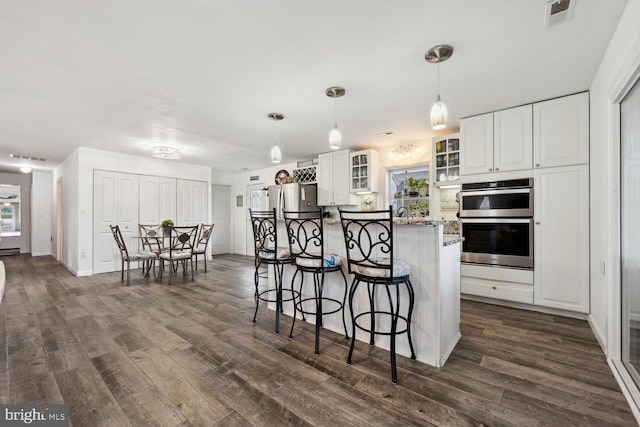 644 Chester River Beach Rd, Grasonville, MD 21638 - kitchen with stainless steel appliances, a kitchen breakfast bar, dark wood-style floors, and glass insert cabinets