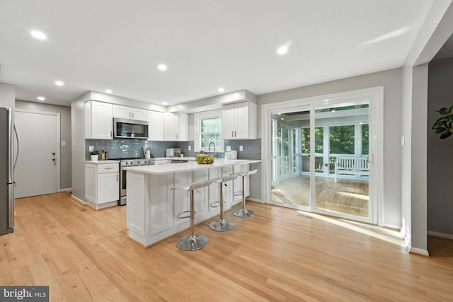6 Ivywood Ct, Silver Spring, MD 20904 - kitchen with stainless steel appliances, a breakfast bar, light wood finished floors, backsplash, and recessed lighting