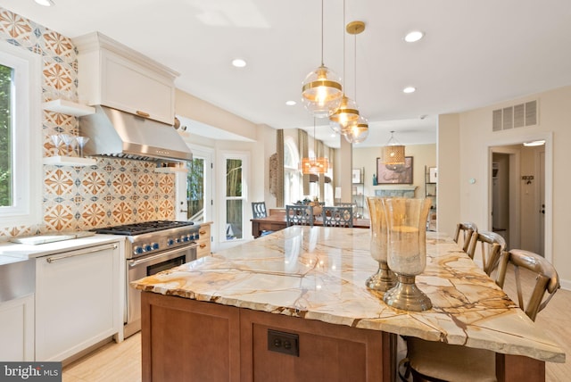 10915 Lamplighter Ln, Potomac, MD 20854 - kitchen with high end stove, range hood, a kitchen island, healthy amount of natural light, and recessed lighting