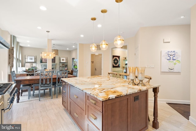 10915 Lamplighter Ln, Potomac, MD 20854 - kitchen featuring a breakfast bar, light stone countertops, brown cabinetry, a center island, and recessed lighting