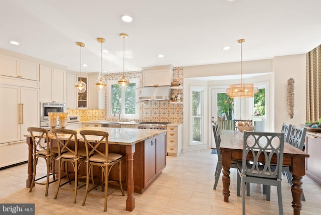 10915 Lamplighter Ln, Potomac, MD 20854 - kitchen featuring built in appliances, a kitchen island, decorative backsplash, light stone counters, and a breakfast bar area