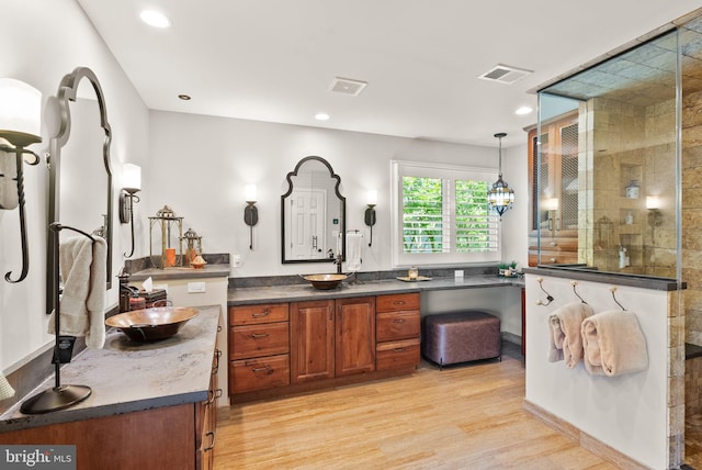 10915 Lamplighter Ln, Potomac, MD 20854 - bathroom featuring two vanities, wood finished floors, a walk in shower, and recessed lighting