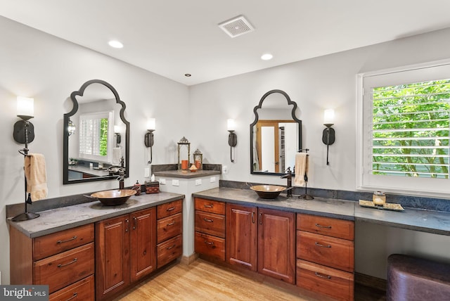 10915 Lamplighter Ln, Potomac, MD 20854 - bathroom featuring two vanities, wood finished floors, and recessed lighting