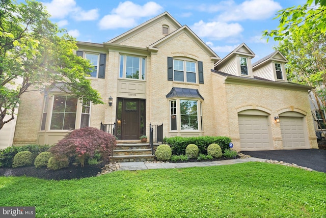 10915 Lamplighter Ln, Potomac, MD 20854 - view of front of house with asphalt driveway, a front lawn, brick siding, and an attached garage