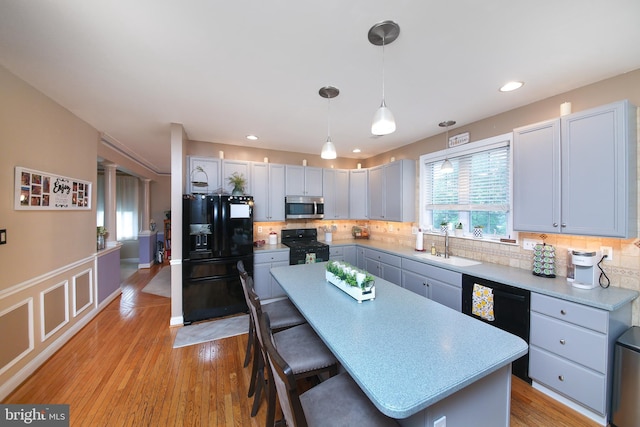 366 High St, Souderton, PA 18964 - kitchen with black appliances, a breakfast bar area, a center island, tasteful backsplash, and hanging light fixtures