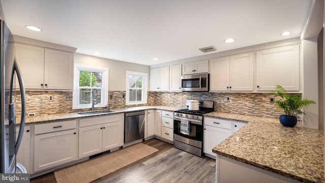 16 E Jefferson St, Newtown, PA 18940 - kitchen featuring appliances with stainless steel finishes, light wood-style floors, tasteful backsplash, light stone counters, and recessed lighting