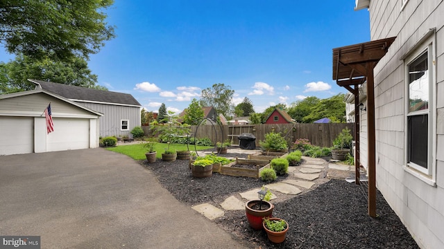 16 E Jefferson St, Newtown, PA 18940 - fenced backyard featuring a vegetable garden, an outbuilding, and a garage