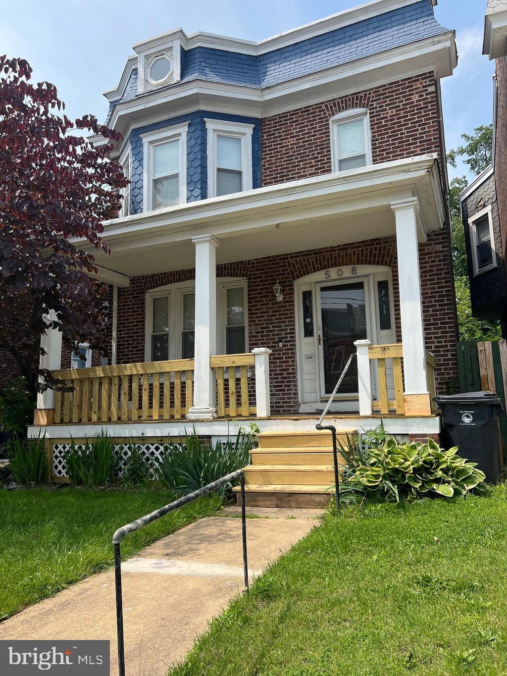 508 W 25th St, Wilmington, DE 19802 - view of front facade featuring brick siding, a porch, and mansard roof