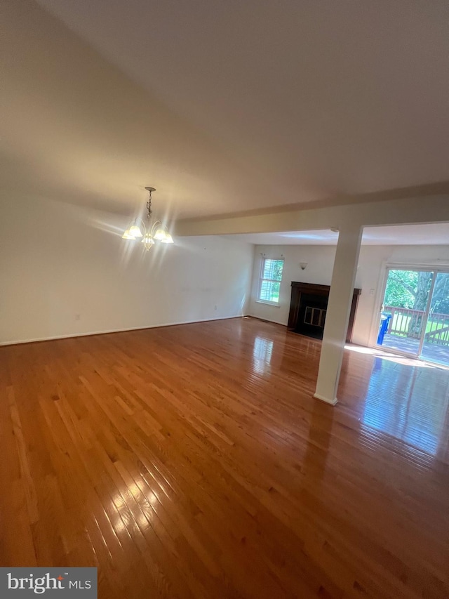 11708 Lone Tree Ct, Columbia, MD 21044 - unfurnished living room with wood finished floors, a chandelier, plenty of natural light, and a fireplace