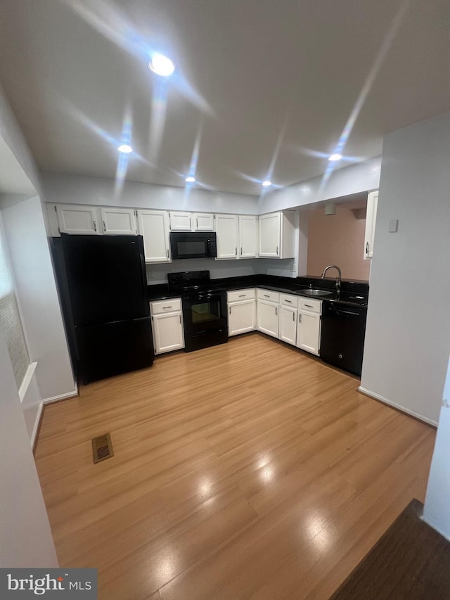 11708 Lone Tree Ct, Columbia, MD 21044 - kitchen with black appliances, dark countertops, white cabinetry, and light wood finished floors