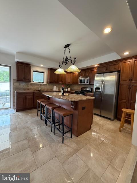 203 W Weymouth Rd, Vineland, NJ 08360 - kitchen with appliances with stainless steel finishes, a center island, tasteful backsplash, a kitchen breakfast bar, and recessed lighting