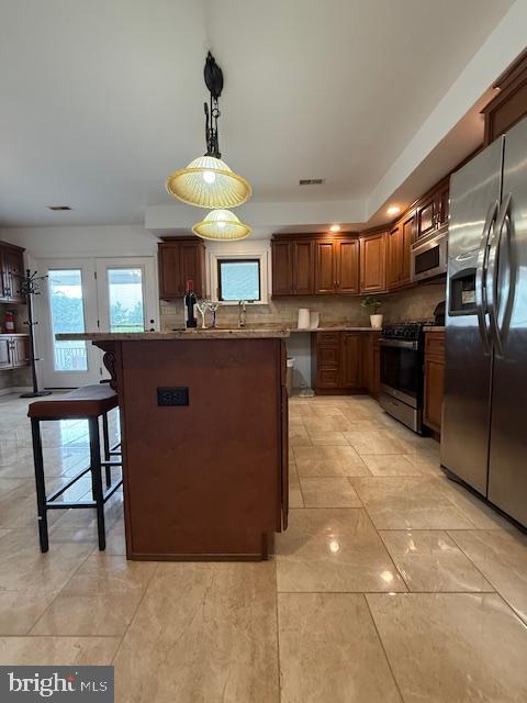 203 W Weymouth Rd, Vineland, NJ 08360 - kitchen with appliances with stainless steel finishes, a kitchen bar, decorative backsplash, and pendant lighting