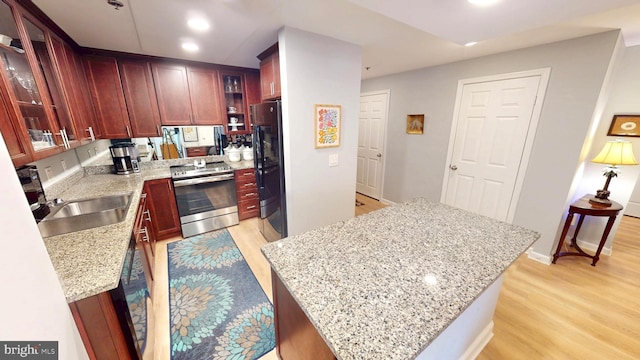 960 Fell St Unit 609, Baltimore, MD 21231 - kitchen featuring stainless steel electric stove, light wood-type flooring, reddish brown cabinets, freestanding refrigerator, and recessed lighting